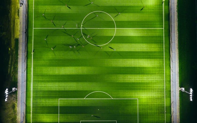 Floodlit pitch from above during an evening match