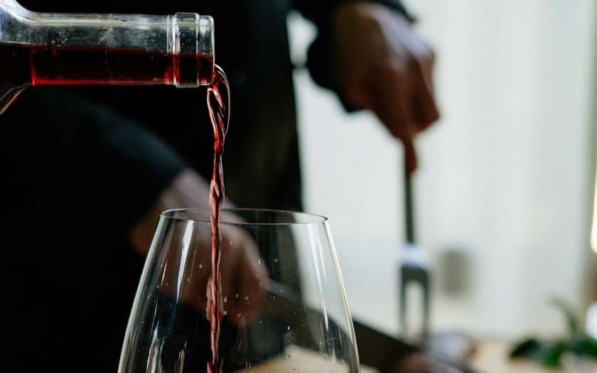 Red wine being poured into a glass at the table
